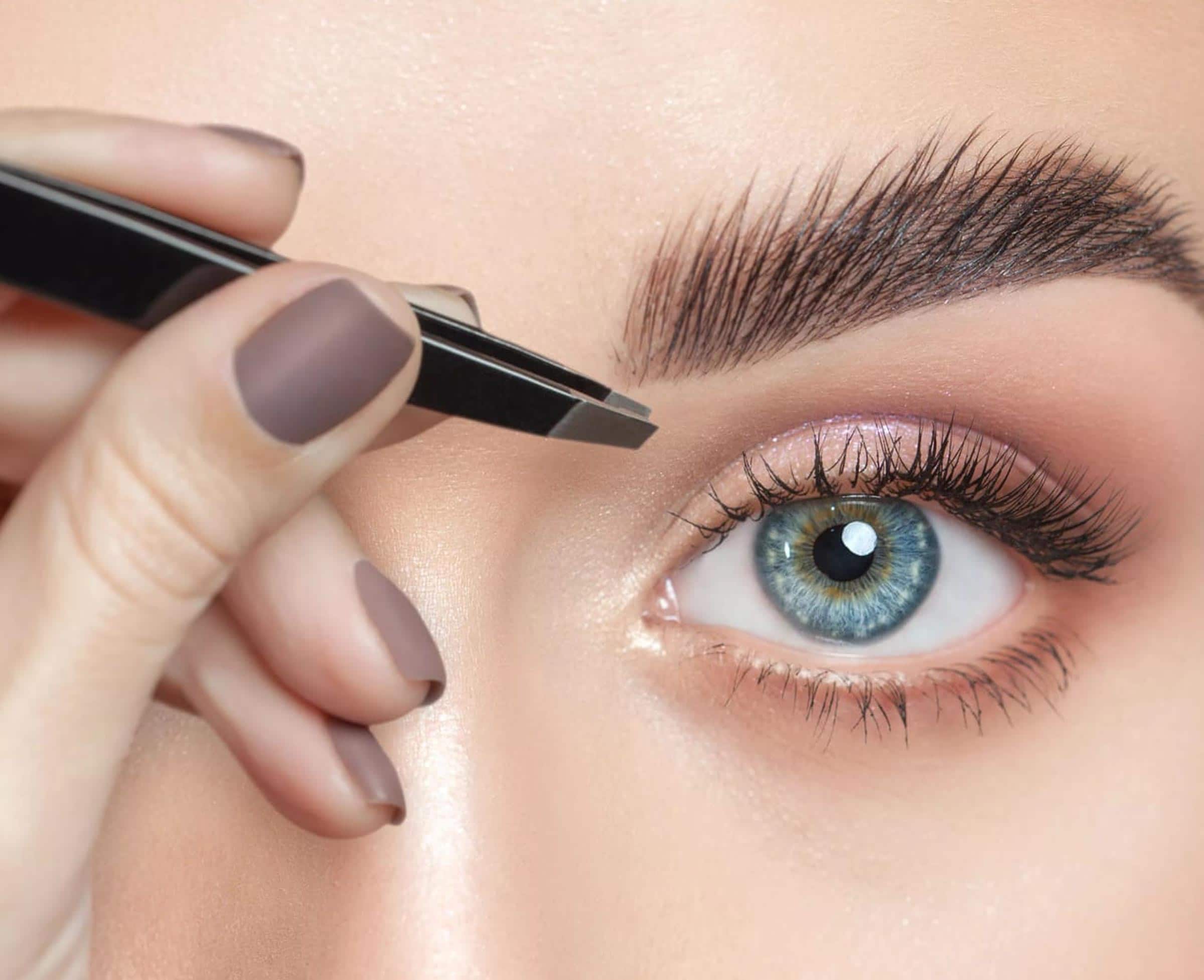 Une femme utilise un crayon à sourcils pour former et définir ses sourcils.