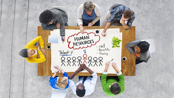 Un groupe de responsables des ressources humaines assis autour d'une table, discutant de la manière de recruter de nouveaux employés.
